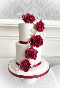 3 tier white wedding cake with stunning deep red sugar roses