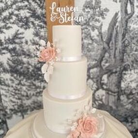 elegant 3 tier white wedding cake decorated with beautiful nude handmade sugar roses and white blossom flowers and foliage