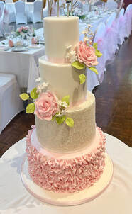 stunning 4 tier weddig cake with pink ruffles and sugar flowers