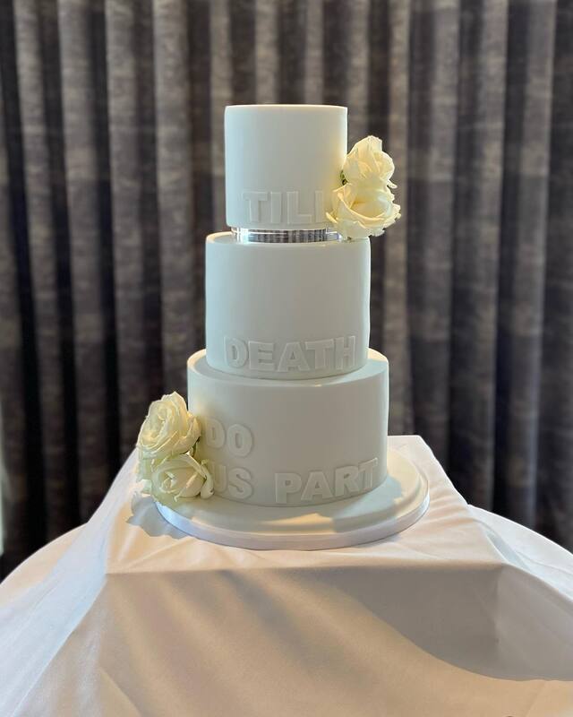 modern 3 tier floating tier white wedding cake with death do us part wording and fresh white roses